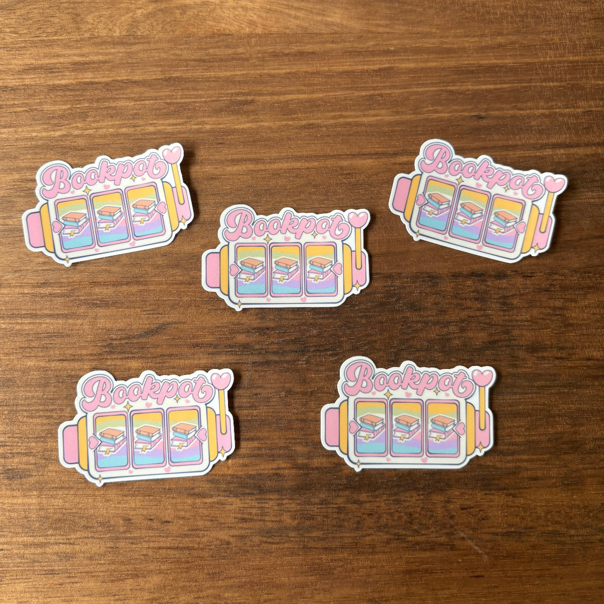 Five pastel-colored stickers with 'Bookaroo' text on a wooden surface